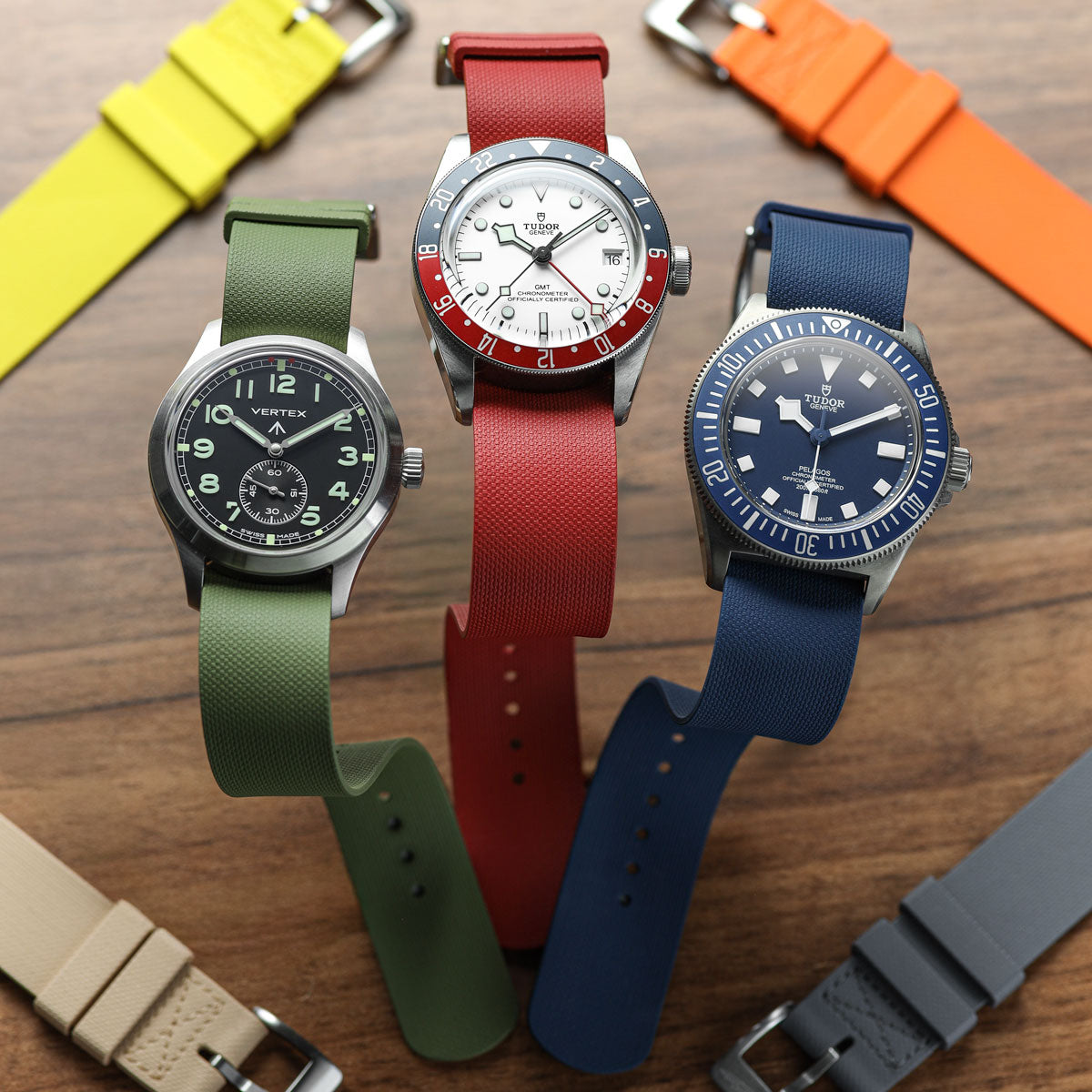 Watches with different colored straps on a wooden surface
